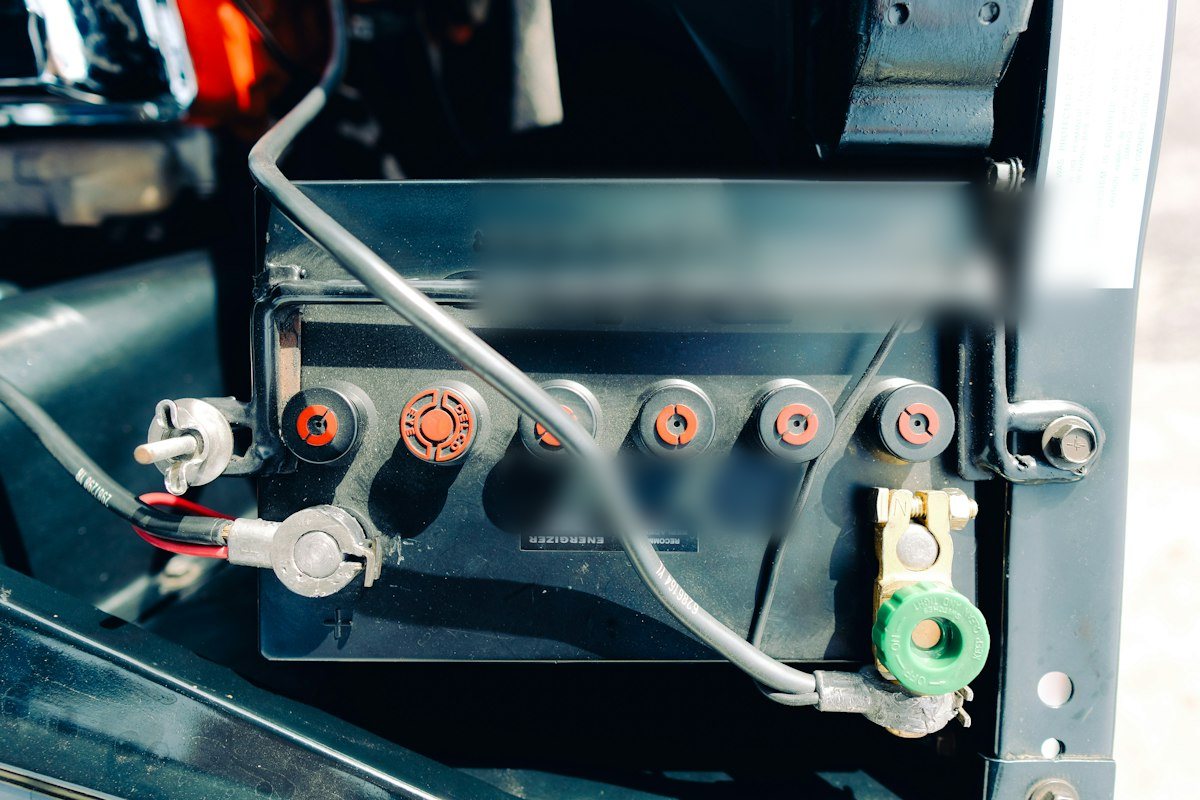 A close-up of a car battery with its cables and terminals connected